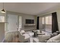 Cozy living room featuring sliding glass doors with modern furniture and entertainment center at 5710 E Tropicana Ave # 1216, Las Vegas, NV 89122