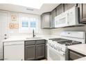 Cozy kitchen with white appliances, grey cabinets, a window over the sink, and bright natural lighting at 595 Sellers Pl, Henderson, NV 89011