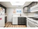 Charming kitchen featuring grey cabinets, white appliances and countertops, and wood-look flooring at 595 Sellers Pl, Henderson, NV 89011