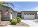 Inviting home exterior with desert landscaping, a two-car garage, and a decorative wrought-iron front door at 6173 Sabine Ranch Rd, Las Vegas, NV 89131