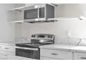 Modern kitchen featuring stainless steel appliances, marble countertops, and white cabinets with gold accents at 6204 Robin Hood Cir, Las Vegas, NV 89108