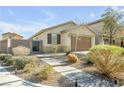 Charming single-story home with desert landscaping, a paved walkway, and a well-manicured lawn at 6318 Amber Sunrise St, North Las Vegas, NV 89031