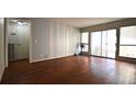 Bright living room with hardwood floors, neutral paint, sliding glass doors, and modern ceiling fan at 634 Oakmont Ave # 1903, Las Vegas, NV 89109