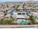 Aerial view of property showcasing a backyard oasis with pool, hot tub, solar panels, and covered patio at 7504 Frittata Ave, Las Vegas, NV 89113