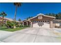 Well-maintained home featuring a two-car garage, desert landscaping, and a classic tile roof in a sunny setting at 906 Sitting Bull Dr, Henderson, NV 89014