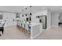 Bright, open kitchen featuring a large island with seating, white cabinets, and stainless steel appliances at 9643 Wildflower Vista Ave, Las Vegas, NV 89166