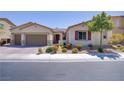 Attractive single-story home with a three-car garage, lush landscaping, and a beautifully maintained front yard at 9779 Mosaic Canyon Ct, Las Vegas, NV 89149