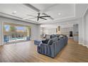 A spacious living room with recessed lighting, hardwood floors, and a large sectional sofa near a glass patio door at 9779 Mosaic Canyon Ct, Las Vegas, NV 89149