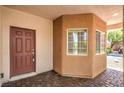 Inviting front entrance to a home featuring a dark brown door with brick pavers and unique window at 11625 Cabo Del Verde Ave, Las Vegas, NV 89138