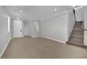 Spacious living room with tile flooring, recessed lighting, and a staircase at 11787 Fern Creek Ln, Las Vegas, NV 89183