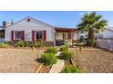 Inviting home exterior with lush landscaping, a cozy porch and rock ground cover at 123 Cedar St, Henderson, NV 89015