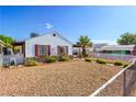 Charming home exterior with low maintenance landscaping and a white picket fence at 123 Cedar St, Henderson, NV 89015