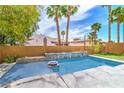 Backyard pool area featuring a custom water feature and lush landscaping at 1448 Canyon Ledge Ct, Las Vegas, NV 89117
