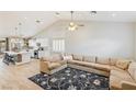 Bright open-concept living room with vaulted ceilings, tile floors, and a large sectional sofa at 1845 Candle Bright Dr, Henderson, NV 89074