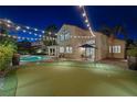 Well-manicured backyard with a putting green, pool, and string lights for outdoor enjoyment at 1921 Spyglass Dr, Henderson, NV 89074
