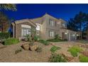 Charming two-story home with stone accents, a three-car garage, and desert landscaping at 1921 Spyglass Dr, Henderson, NV 89074