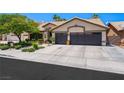 Attractive single-story home with desert landscaping and a spacious driveway leading to a three-car garage at 211 Kokopelli Ct, Henderson, NV 89074