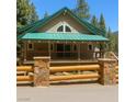 Attractive home with a green metal roof, stone and wood fence, and large front porch at 4178 Matterhorn Way, Las Vegas, NV 89124