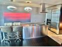 Modern kitchen featuring stainless steel appliances, island with seating, and unique pendant lighting at 4381 W Flamingo Rd # 2022, Las Vegas, NV 89103