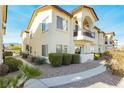 Desirable townhouse with stucco exterior, stone landscaping, private balcony, and inviting walkway at 4810 Grey Wolf Ln # 104, Las Vegas, NV 89149