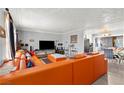 Bright living room featuring a large orange sectional sofa and neutral walls at 5004 Cannon Blvd, Las Vegas, NV 89108