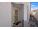 Covered front entry with a screen door and a 'hello' welcome mat in a home with textured walls at 509 Regal Robin Way, North Las Vegas, NV 89084