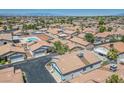 An aerial view of a neighborhood showcasing houses with well-manicured yards and a pool at 5099 Mascaro Dr, Las Vegas, NV 89122