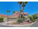 Charming home featuring a two-car garage and desert landscaping with mature palm trees at 5237 Crooked Sky Cir, Las Vegas, NV 89149