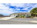 Attractive home featuring a three-car garage, desert landscaping, and ample parking space at 5500 Santovito St, Pahrump, NV 89061
