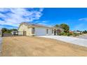Single-story home featuring a three-car garage, desert landscaping, and gated driveway at 5500 Santovito St, Pahrump, NV 89061