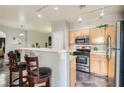 Open kitchen layout with bar seating, stainless steel appliances, and wood cabinets at 6321 Rolling Rose St # 201, North Las Vegas, NV 89081