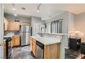 Functional kitchen with stainless steel appliances, wooden cabinets, and a sink with stainless steel faucet at 6321 Rolling Rose St # 201, North Las Vegas, NV 89081