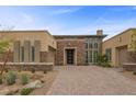 Stunning home exterior with a stone facade, brick driveway, and desert landscaping at 6700 Regency Stone Way, Las Vegas, NV 89148
