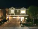 Well-lit two-story house with a two-car garage, manicured lawn, and paved driveway at night at 6729 Flamenco Ct, Las Vegas, NV 89139