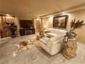 Elegant living room with marble floors, plush seating, stylish decor, and a large screen television at 6729 Flamenco Ct, Las Vegas, NV 89139