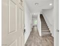 Inviting entryway featuring wood-look flooring, stairs to the upper level, and neutral walls at 7977 Whisper Words Ave, Las Vegas, NV 89113