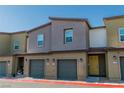 Row of modern townhouses, each with a one-car garage and a unique color scheme at 7977 Whisper Words Ave, Las Vegas, NV 89113
