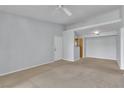 Open-concept living room featuring neutral carpeting and access to a hallway and kitchen at 8000 Badura Ave # 2174, Las Vegas, NV 89113
