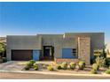 Modern home with a gray exterior, contrasting stone accents, and desert landscaping at 10228 Shell Star Ave, Las Vegas, NV 89135