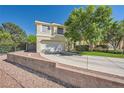 Charming two-story home with a well-kept lawn, concrete driveway, and tasteful landscaping and rock decorations at 1116 Avellino Ln, Las Vegas, NV 89144