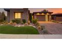 Stylish home exterior featuring desert landscaping, stone details, and an inviting driveway at 15 Reflection Bay Dr, Henderson, NV 89011
