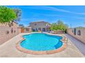 Beautiful backyard featuring a refreshing blue pool, concrete patio, and secure fencing with desert landscaping at 201 Palmarosa St, Henderson, NV 89015