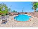 Inviting backyard featuring a sparkling pool, a built-in BBQ island, and lush desert landscaping for relaxation at 201 Palmarosa St, Henderson, NV 89015