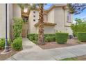 Inviting townhome exterior with lush greenery, a paved walkway, and a charming entrance at 2050 W Warm Springs Rd # 823, Henderson, NV 89014