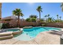 Inviting backyard pool and spa surrounded by lush palm trees under a clear blue sky at 2713 Tanagrine Dr, North Las Vegas, NV 89084