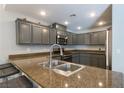 Modern kitchen featuring granite countertops, stainless steel appliances, and gray cabinets at 3728 Juanita May Ave, North Las Vegas, NV 89032