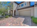 Two-story home with a two-car garage, brick paved driveway, and well-kept landscaping in front at 5244 Fiery Sky Ridge St, Las Vegas, NV 89148
