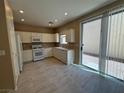 Bright kitchen features white cabinetry, appliances, and a sliding glass door leading to the backyard at 5861 Varese Dr, Las Vegas, NV 89141