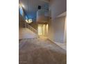 Spacious living room with soaring ceilings, elegant chandelier, and staircase at 5861 Varese Dr, Las Vegas, NV 89141