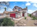 Charming two-story home features a red garage door, a tile roof, and xeriscape landscaping at 6374 Horizon Ridge Ct, Las Vegas, NV 89156